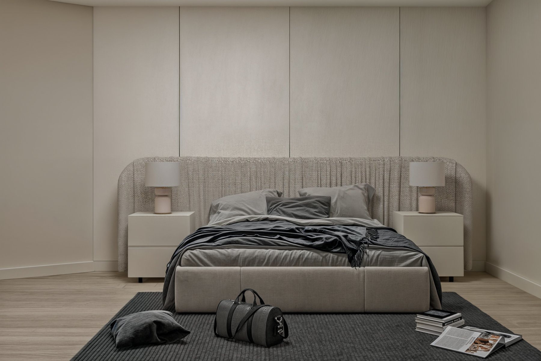 غرفة نوم مودرن بتصميم أنيق تضم سرير مبطن بلون محايد، دولاب زجاجي داكن بإضاءة داخلية، وتسريحة معلقة بمرآة مضيئة، مناسبة لغرف النوم العصرية في المنازل السعودية.